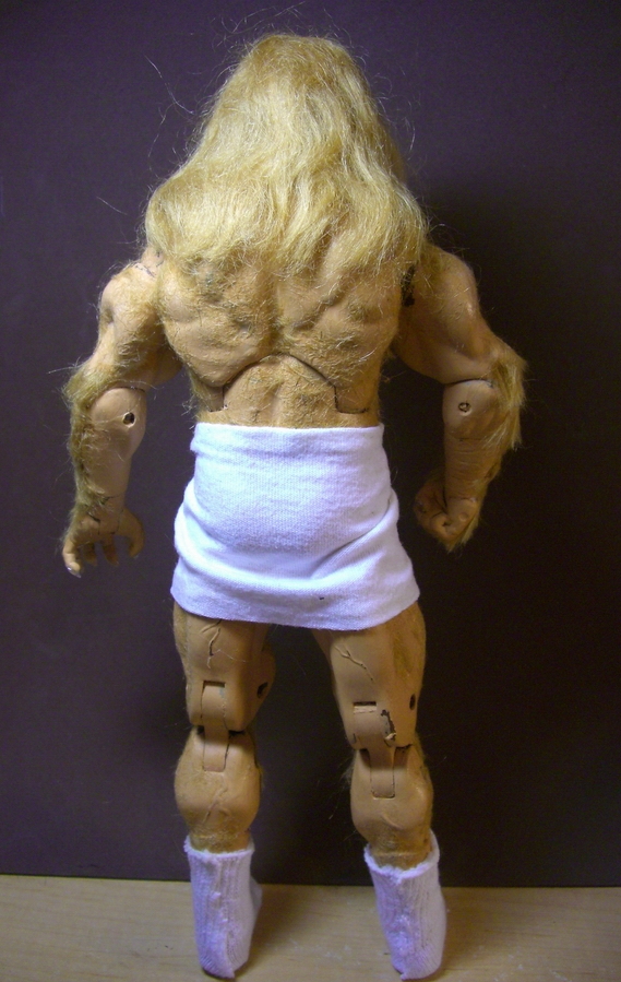 A rear view  of a Vincent doll wearing an artistically draped towel a round his cute tush and comfy socks on his feet.  His broad back ripples with muscles and his golden mane just begs to be touched.
