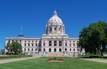 white stone building with a dome, reminiscent of the US capitol building
