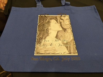 large blue canvas bag with con logo on one side